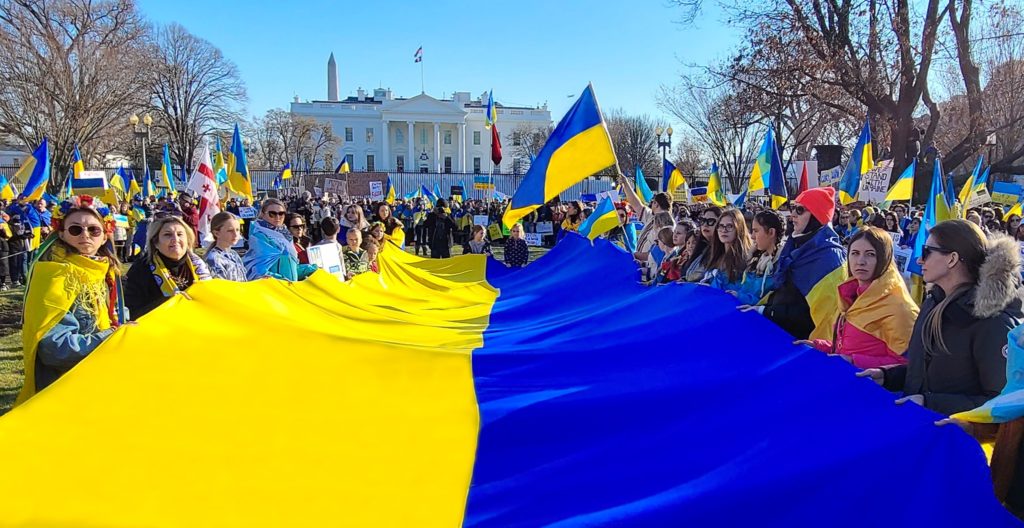 Demonstrators hold Ukrainian flags in front of the White House