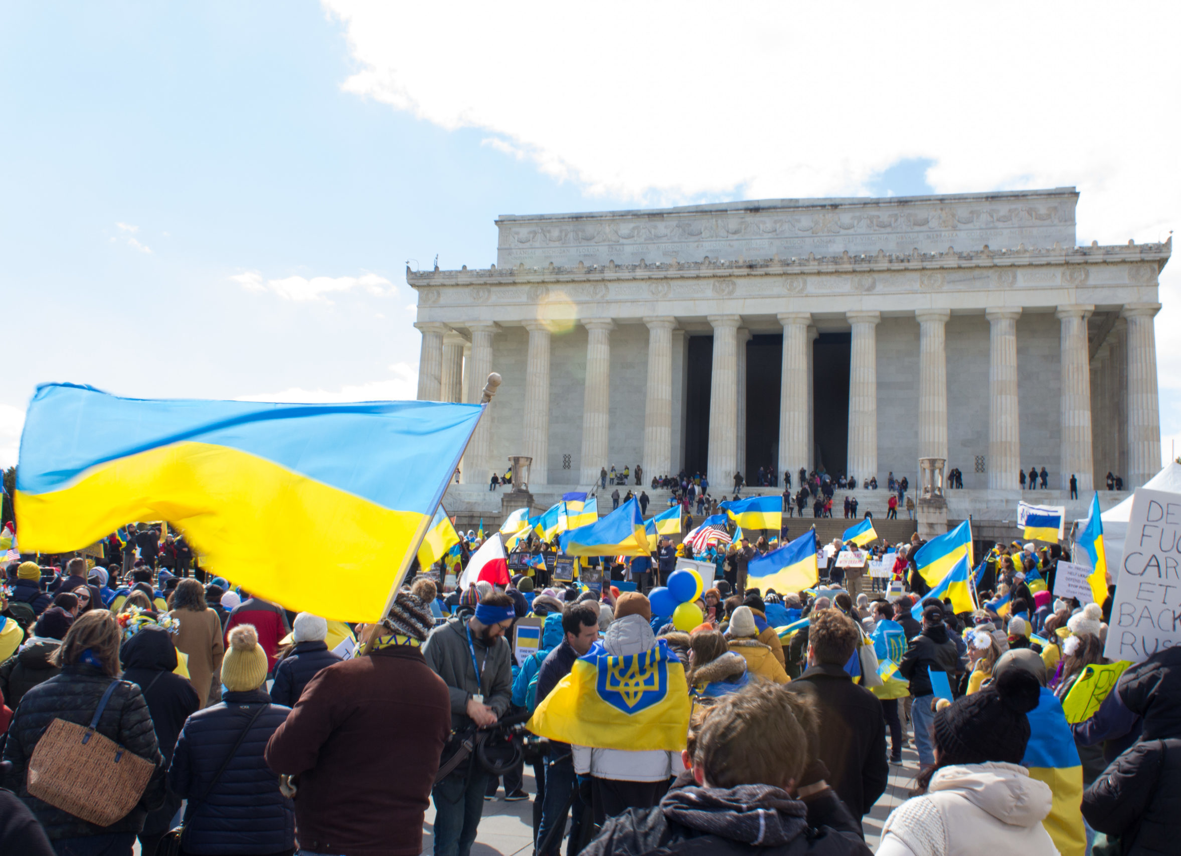 Demonstrators hold Ukrainian flags and signs in front of the Lincoln memorial, Washington DC